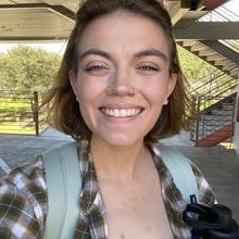 Woman wearing backpack carrying waterbottle