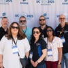 Attendees smiling in front of the UC Tech backdrop.