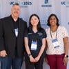 Conference Chair, Azra Ayers (R), and Co-Chairs, Mike Kennedy (L) and Kayla Lee (C), smiling in front of the UC Tech backdrop.