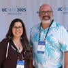 Attendees smiling in front of the UC Tech backdrop.