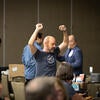 Attendee happily raising their arms up after winning a raffle prize.
