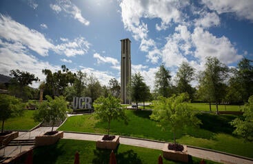 Aerial view of the UCR Bell Tower, with trees and the sky in the background
