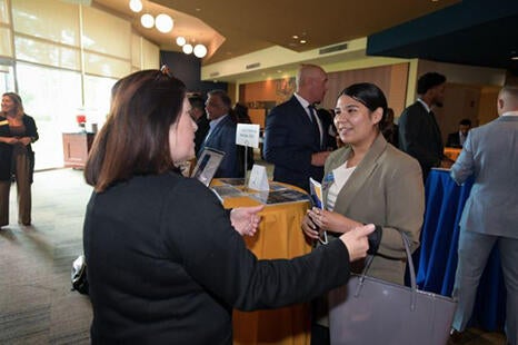 A student in professional attire talking to an employer at the AGSM Graduate Talent Forum 2025
