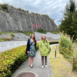 Leadership team standing in front of OIST campus sign