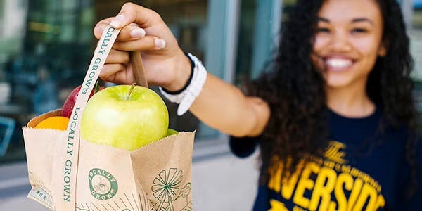 Student holding a basic needs package