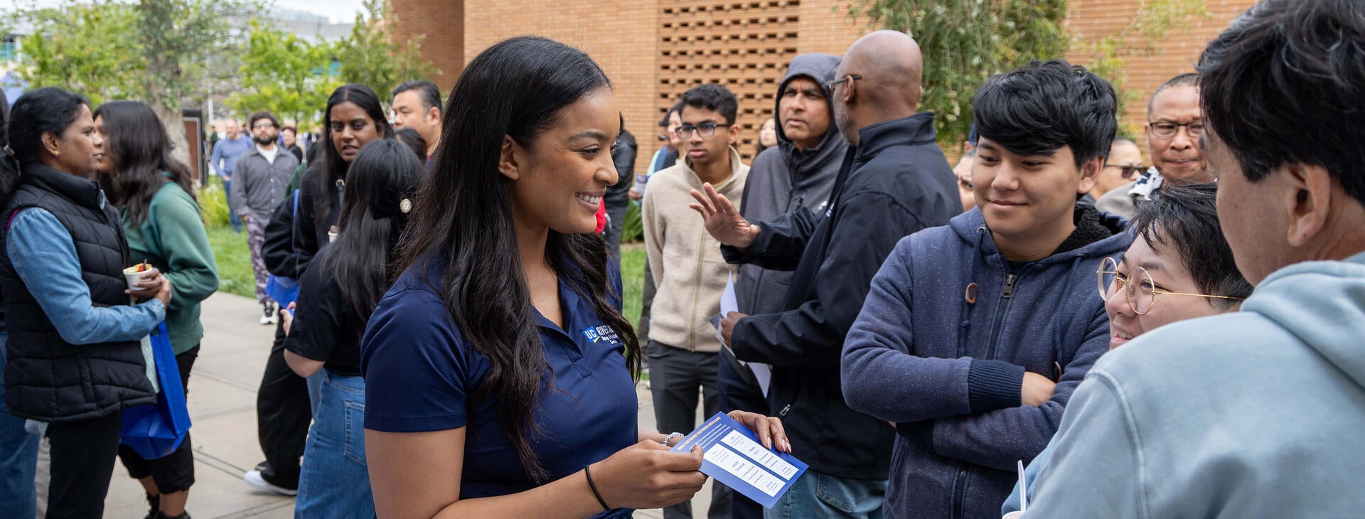 Personal de UC Riverside hablando con las familias en el Highlander Day, una jornada de puertas abiertas para los estudiantes universitarios admitidos