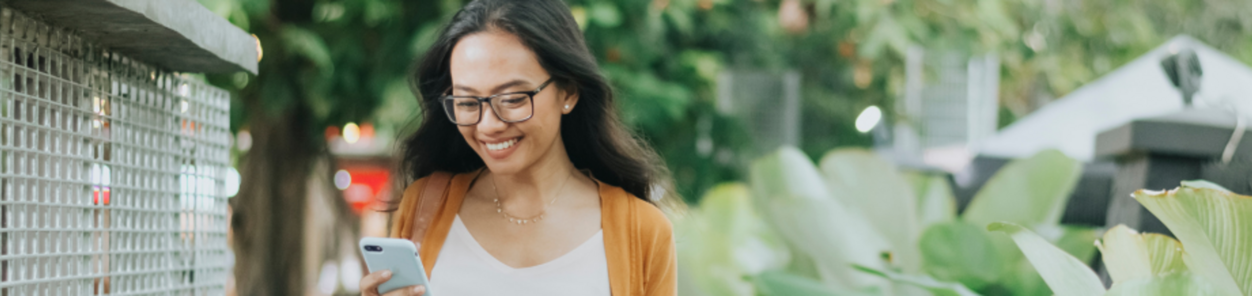 woman walking and looking at her phone
