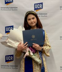 Alumna Ngoc Dang holding her certificate and flowers from UCR University Extension