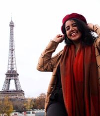 UCR University Extension graduate Sahara Powell standing in front of the Eiffel Tower in Paris