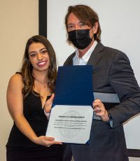 Thayna De Lima Costa accepting her PGD certificate from Dean Kevin Vaughn