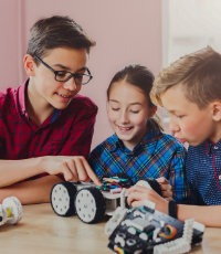 3 elementary-aged children building a robot car