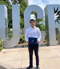 UCR University Extension student Leo Tomaya standing in the UCR metal letters