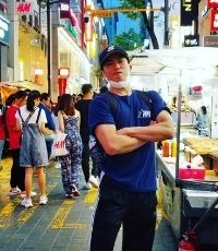 Asian man standing with arms crossed in the city