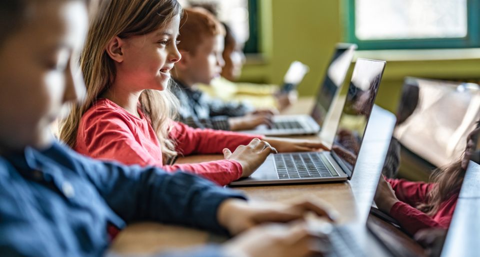 Elementary school students working on laptops