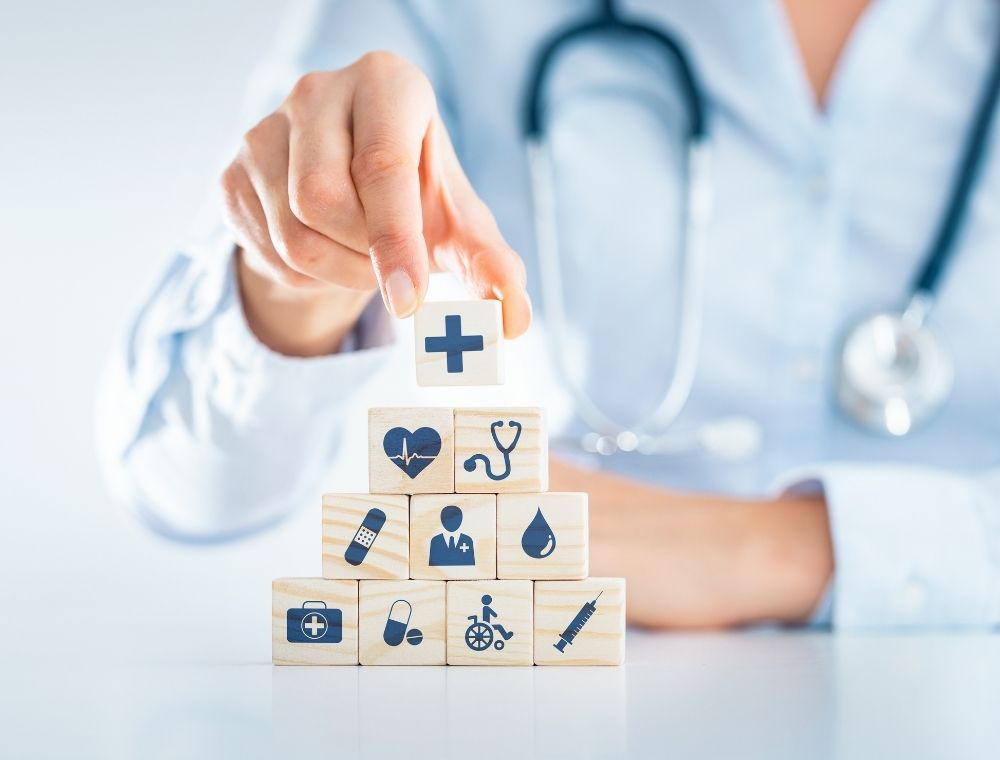 Doctor building health blocks with various health symbols